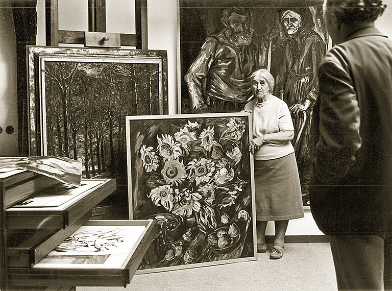 Hanna Böckstiegel, die mit ihren Kindern das Werk ihres Mannes nach seinem Tod gepflegt und der Öffentlichkeit zugänglich gemacht hat, zeigt einem Besucher im "Neuen Atelier" des Böckstiegel-Hauses Gemälde aus dem Nachlass des Künstlers